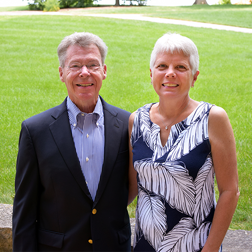 Joann & Michael Youngman standing outside in a formal portrait.